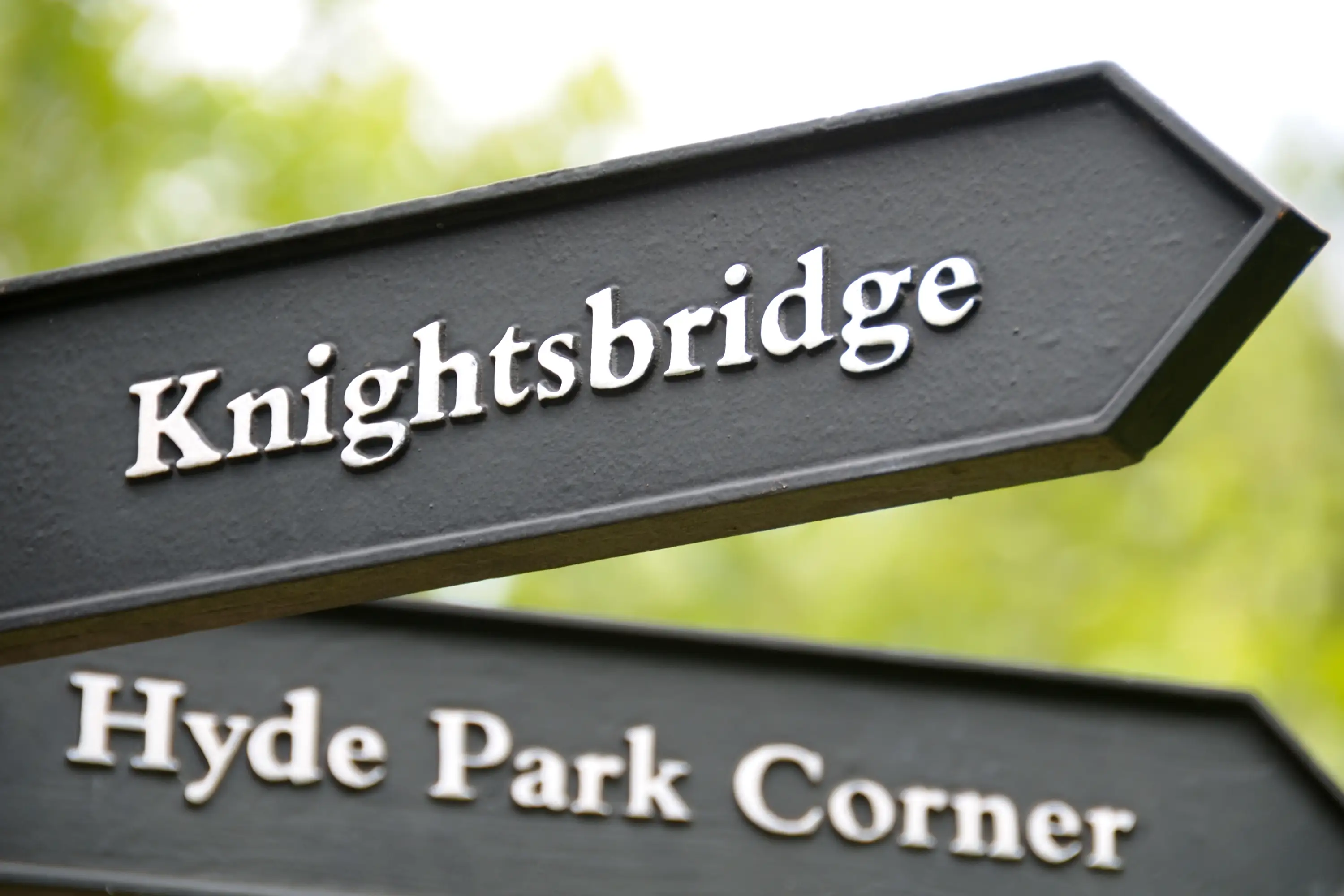 Black and white vintage sign pointing towards Knightsbridge and Hyde Park Corner