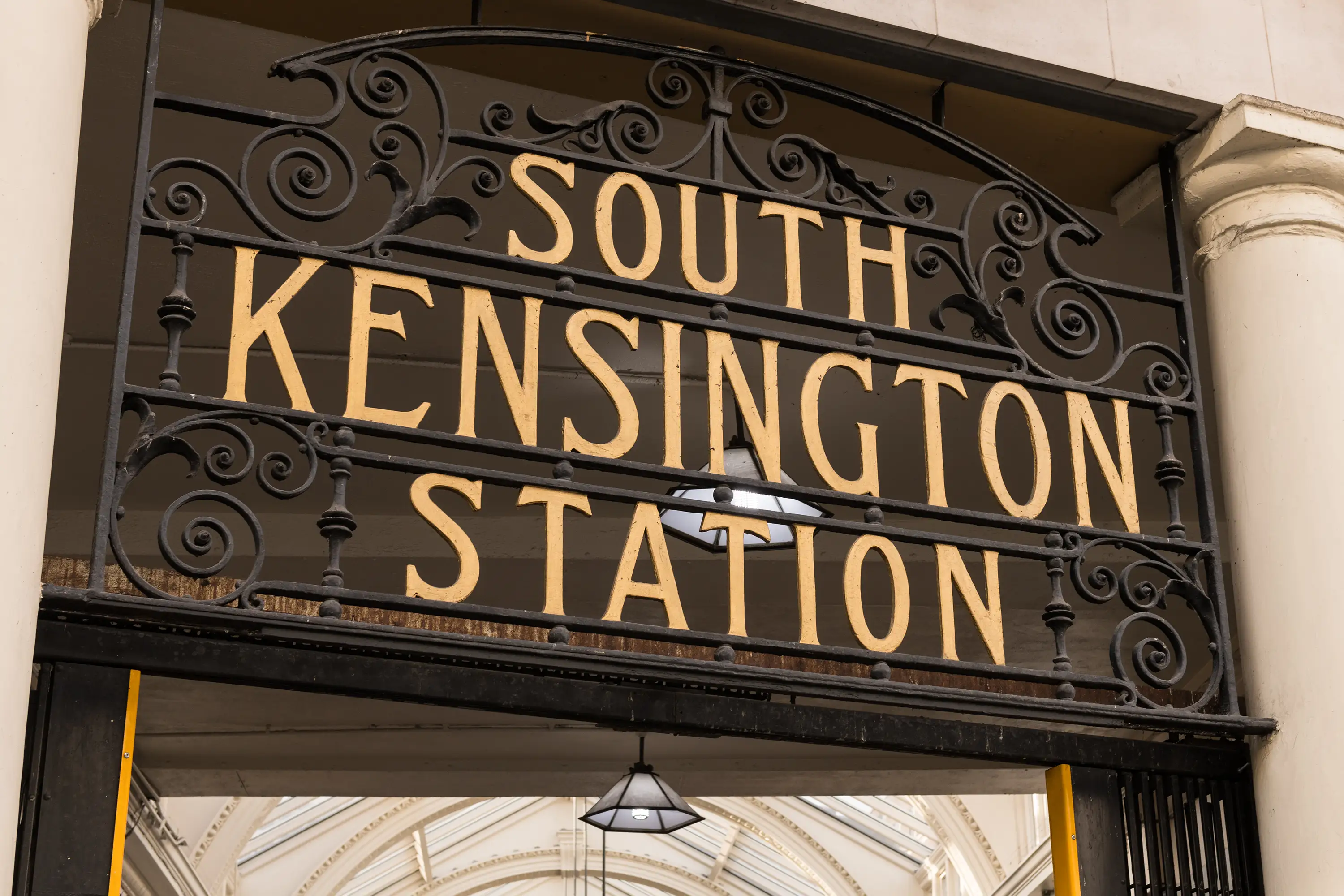 Black and gold metal sign saying South Kensington Station