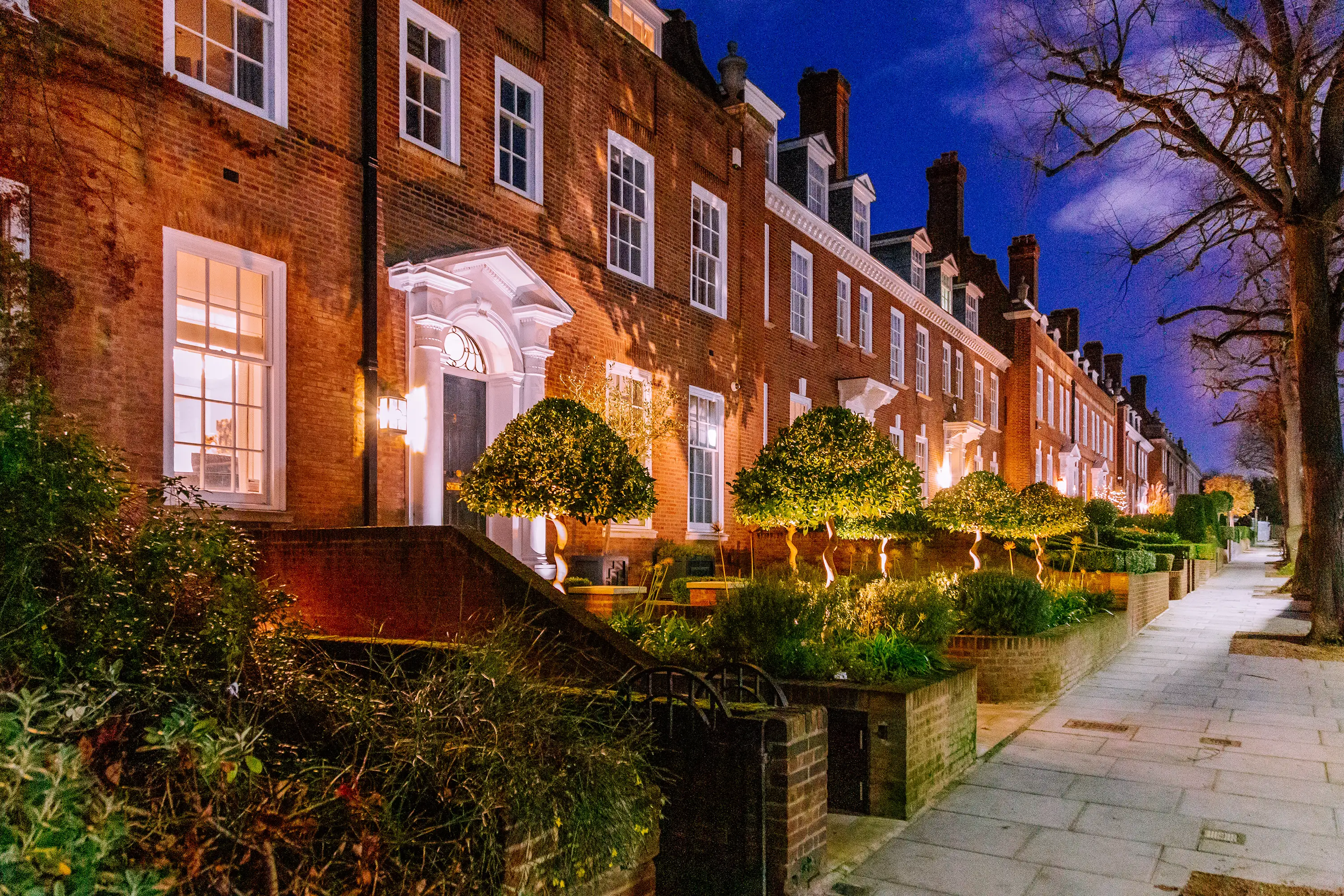Holland Park home at dusk. House lit up.